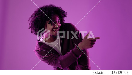 Young stylish man pointing his finger laughing on purple background Young stylish man pointing his finger laughing on purple background 132589198