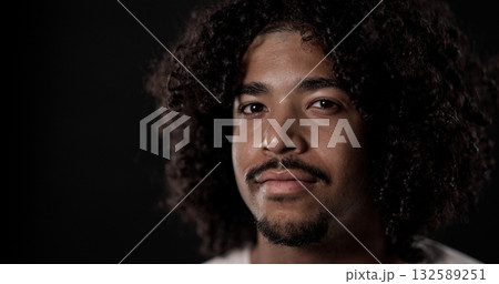 Young African American man with curly hair and goatee posing in studio 132589251