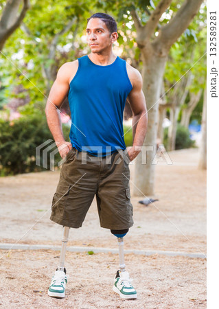 Disabled athlete standing with prosthetic legs in park Disabled athlete standing with prosthetic legs in park 132589281