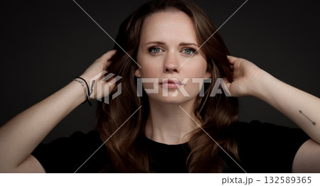 Young woman touching her hair with small arrow tattoo 132589365