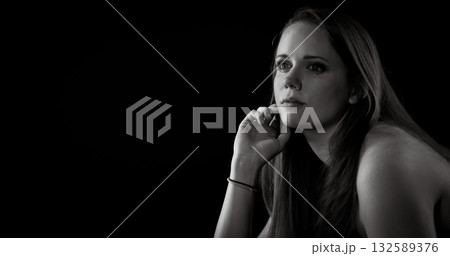 Pensive young woman holding her face and thinking in black and white 132589376