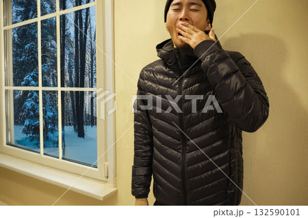 冬の朝、あくびをする若い男性 132590101