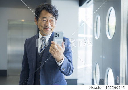 スマートフォンを持つビジネスマン　 132590445