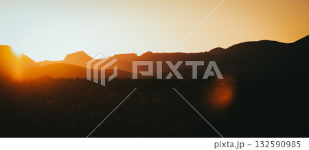 Timanfaya volcanoes and mountains in the rays of a sun. 132590985