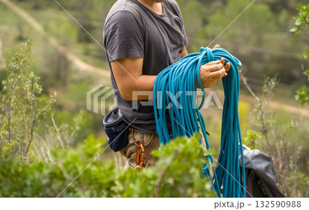 Man with a rope climbing in the mountains. Technical mountaineering. 132590988