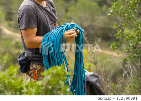 Man with a rope climbing in the mountains. Technical mountaineering. 132590991