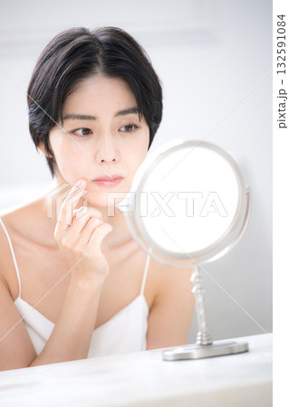 鏡を見てスキンケアの悩みを気にする女性のクローズアップ 132591084