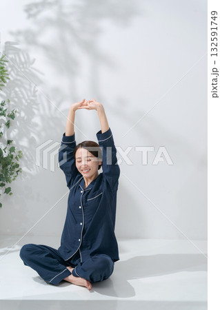 伸びをするパジャマの女性 132591749