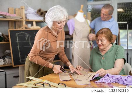 Elderly man and woman working with mannequin and making pattern in class Elderly man and woman working with mannequin and making pattern in class 132592310