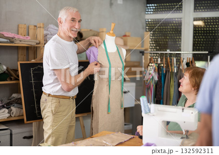 Aged sewing instructor teaching garment modeling using dress form 132592311