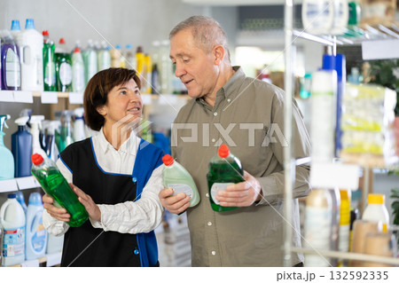 Woman seller offers dishwashing to elderly man buyer Woman seller offers dishwashing to elderly man buyer 132592335