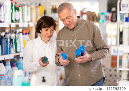 Couple man and woman choosing garbage bags in store Couple man and woman choosing garbage bags in store 132592399
