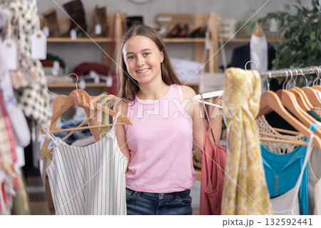 Teenage girl choosing top in clothing store Teenage girl choosing top in clothing store 132592441