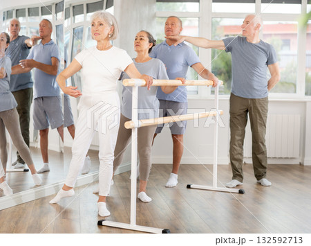 Male choreographer teaches elderly ballet lovers to keep their heads straight during ballet lesson 132592713