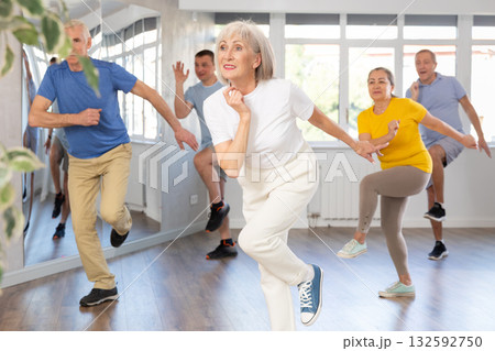 Woman participating in Zumba class for seniors in fitness studio 132592750