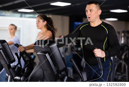 Fit male athlete working out at elliptical machine in gym Fit male athlete working out at elliptical machine in gym 132592800