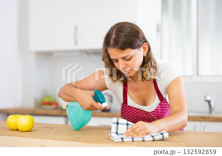 Young woman cleaning kitchen countertop at home Young woman cleaning kitchen countertop at home 132592859