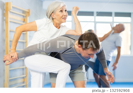 Old woman practicing self-defense techniques in pairs 132592908