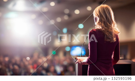 Female speaker presenting at a conference with audience engaged in a professional setting 132593196