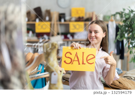 Teen holding poster with the inscription sale Teen holding poster with the inscription sale 132594179