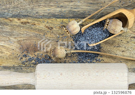 Poppy seeds and several dried poppy seed pods on wooden table Poppy seeds and several dried poppy seed pods on wooden table 132596876