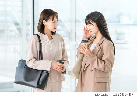 風邪,体調不良,頭痛で上司に相談,報告するビジネスウーマン 風邪,体調不良,頭痛で上司に相談,報告するビジネスウーマン 132599497