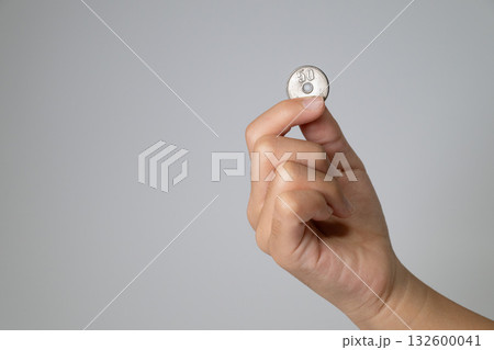 50円硬貨を指先でつまむ子供の手 50円硬貨を指先でつまむ子供の手 132600041