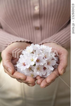  A woman with her hands full of flowers 132600419