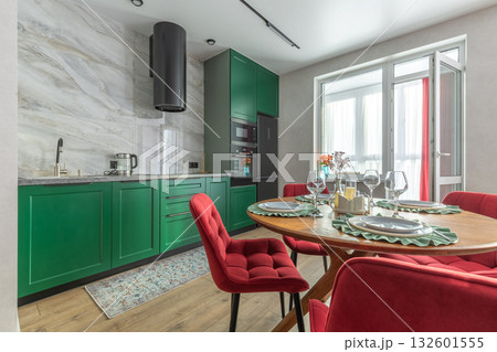 Modern Kitchen Interior with Green Cabinets and Red Chairs 132601555