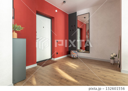 Modern Hallway with Red Accent Wall and Large Mirror 132601556