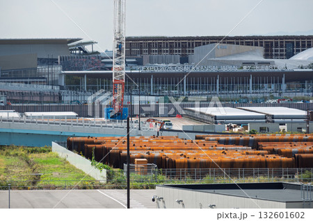 大阪・関西万博東ゲートと大屋根リング前に山積みされた建設用鋼管杭(夢洲・IR基礎工事イメージ) 大阪・関西万博東ゲートと大屋根リング前に山積みされた建設用鋼管杭(夢洲・IR基礎工事イメージ) 132601602