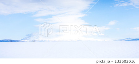 不思議な雲と青空と雪原と冠雪した山のシンプルな風景 132602016