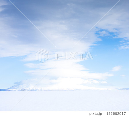 不思議な雲と青空と雪原と冠雪した山のシンプルな風景 不思議な雲と青空と雪原と冠雪した山のシンプルな風景 132602017