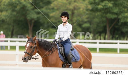 乗馬クラブで馬に乗る日本人女性 132602254