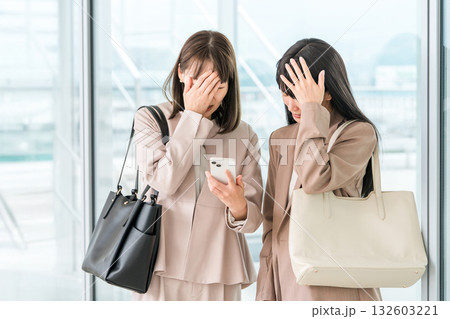 スマホを見ながらショックを受けるビジネスウーマン 132603221