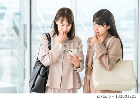 スマホを見ながらショックを受けるビジネスウーマン 132603223