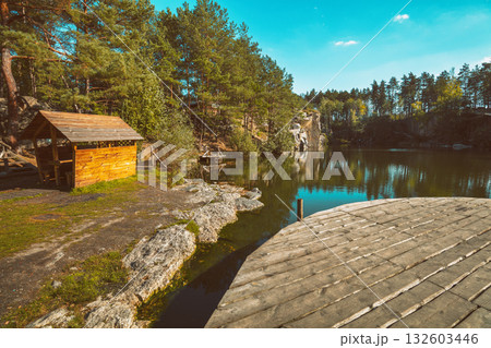 Pine trees on the shore of the lake. Serene lake. Wooden gazebo on the shore of the lake. Wooden round pier on the lake Pine trees on the shore of the lake. Serene lake. Wooden gazebo on the shore of the lake. Wooden round pier on the lake 132603446