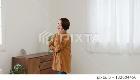 窓際で電話　女性　イメージ 132604456