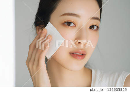 スキンケア中の若い日本人女性。コットンで素肌をケアするクローズアップ 132605396