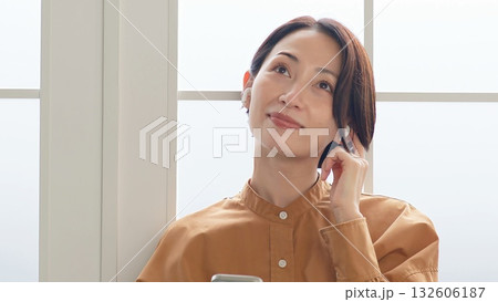 窓際で音楽やラジオを聴いている女性 窓際で音楽やラジオを聴いている女性 132606187
