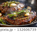 Succulent steak cooking in a skillet with fresh herbs 132606739