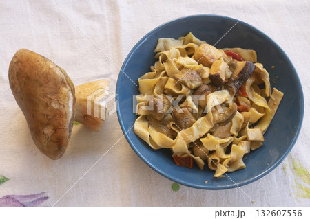handmade egg pappardelle pasta in blue bowl with fresh porcini mushroom 132607556