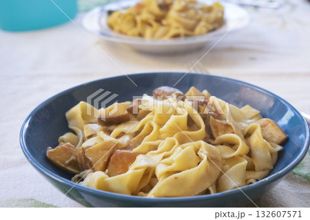 homemade egg pappardelle with porcini mushrooms in blue bowl homemade egg pappardelle with porcini mushrooms in blue bowl 132607571