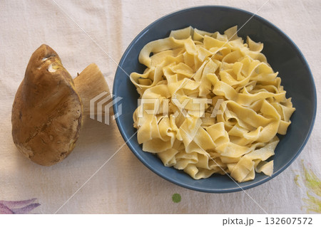 handmade egg pappardelle pasta in blue bowl with fresh porcini mushroom 132607572
