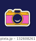 A vector illustration showcases a charming Y2K-style camera sticker. It is designed with a smiley face in the lens, and outlined in cheerful yellow and pink colors. 132608261