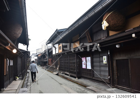 日本の岐阜県 高山市の古い町並 杉玉を飾る酒屋と散歩をする男性 春の高山祭期間中の朝の様子 日本の岐阜県 高山市の古い町並 杉玉を飾る酒屋と散歩をする男性 春の高山祭期間中の朝の様子 132609541