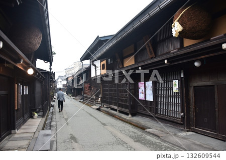 日本の岐阜県　高山市の古い町並　杉玉を飾る酒屋と散歩をする男性　春の高山祭期間中の朝の様子 132609544