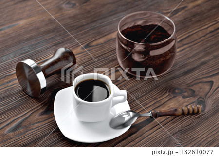 coffee in a cup ground coffee in a glass jar, temper wooden natural background 132610077