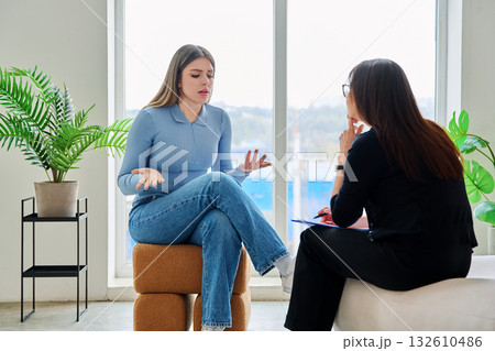 Young woman in a therapy session talking with a psychotherapist 132610486