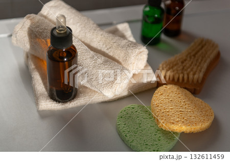 Cosmetic serum glass dropper bottles in bathroom with towel on sunshine 132611459